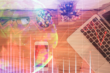 Double exposure of financial graph hologram over desktop with phone. Top view. Mobile trade platform concept.