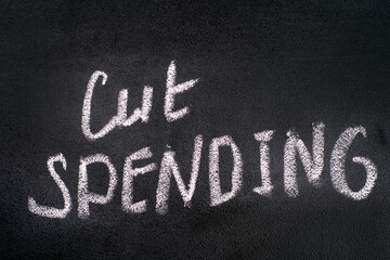 Words Cut Spending written on black board by chalk.