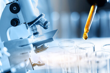 Microscope with laboratory glassware, science research and development concept, dropping chemical...