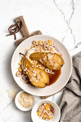 Tasty dessert of baked pears with caramel sauce, cheese cream and almond flakes