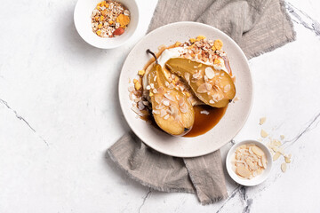 Tasty dessert of baked pears with caramel sauce, cheese cream and almond flakes