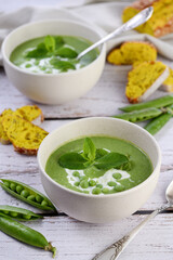 Chilled soup puree of green peas,  seasoned with green onion, mint and crunchy  toasted diced rusk bread  
