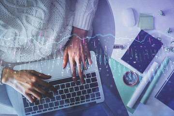 Multi exposure of woman hands working on computer and forex chart hologram drawing. Top View. Financial analysis concept.