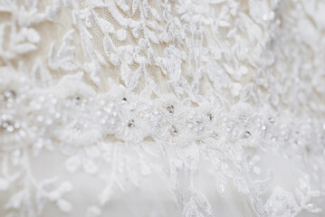 Fototapeta na wymiar the texture of a wedding dress, embroidered with beads, rhinestones and sequins.