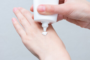 The concept of skin care. Person apply cream on hands, women's hands with cream, close up