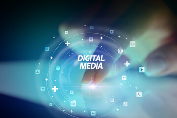 Finger touching tablet with social media icons and DIGITAL MEDIA