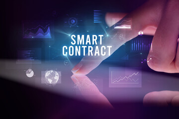 Fototapeta premium Finger touching tablet with charts and SMART CONTRACT inscription, business concept