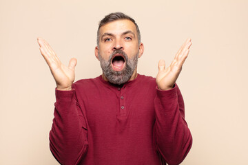 adult handsome man feeling happy, excited, surprised or shocked, smiling and astonished at...
