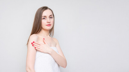 Attractive girl uses body cream, white background, copy space, 16: 9