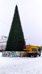Setting up a Christmas tree on a square in the town of Rodniki in Russia. Decorating a Christmas tree in December for Christmas and New Years. Editorial photo 2021.