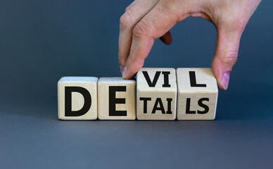 Devil in the details symbol. Businessman hand turns cubes and changes the word 'details' to...