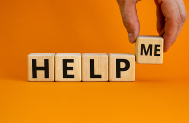 Help me symbol. Businessman holds wooden cubes with words help me. Beautiful orange background,...