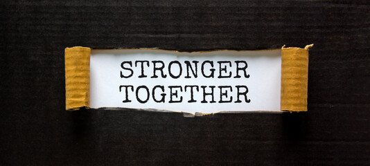 Stronger together symbol. Words Stronger together appearing behind torn black paper. Business, motivational and Stronger together concept. Copy space.