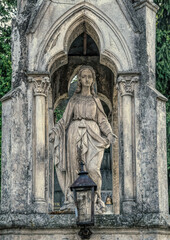 Lviv, Ukraine - July 12, 2019: Ancient gothic Lychakiv cemetery in Lviv, Ukraine. Ancient stone crypts, tombs and gravestones against the backdrop of overgrown green trees and herbs. Famous landmark