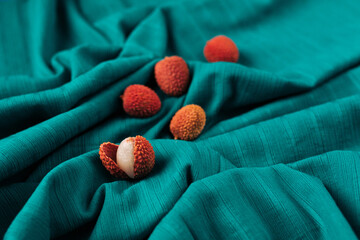 Aesthetic concept of  fresh organic Lychee (Litchi fruit) against bright cyan cloth background.