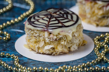 Appetizing cake Esterhazy with cream, chocolate and nuts, side view close-up macro