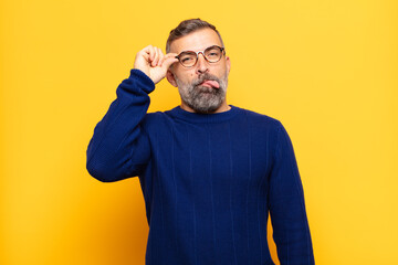 adult handsome man smiling happily with funny face, joking and looking through peephole, spying on...