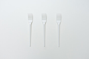 Top view of three plastic forks, white background, copy space