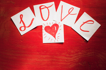 The word "love" is made up of stickers on a red background.