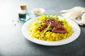 Rice with beef steak and arugula