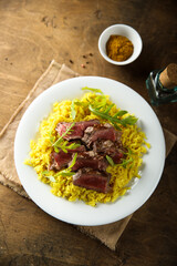 Rice with beef steak and arugula