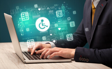 hand browsing on the internet for medical issues with handicapped icons coming out from the screen