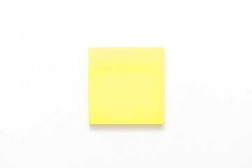 Yellow note paper on white background, copy space
