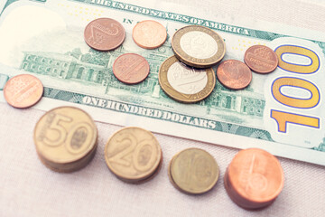 Belarusian rubles, coins and hundred dollars USA, closeup, cropped image, toned