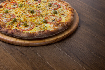 ricardo fernando franca junior pizza mussarela muçarela mucarelMozzarella cheese pizza with slices of red tomatoes on a wooden board. Ample spaces for texts on the right.