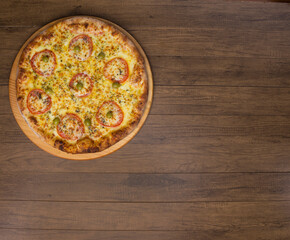 ricardo fernando franca junior pizza mussarela muçarela mucarelMozzarella cheese pizza with slices of red tomatoes on a wooden board. Top photograph .  Space for texts.