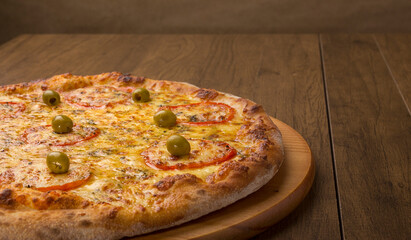 ricardo fernando franca junior pizza mussarela muçarela mucarelMozzarella cheese pizza with slices of red tomatoes on a wooden board. Horizontal gastronomic photography with ample spaces for texts.