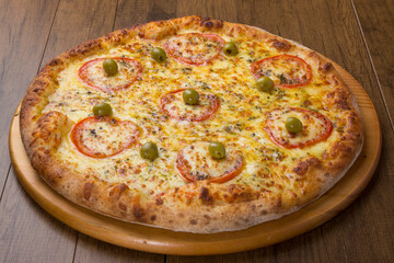 ricardo fernando franca junior pizza mussarela muçarela mucarelTasty mozzarella cheese pizza with slices of red tomatoes on a wooden board. Gastronomic photography with centralized food.