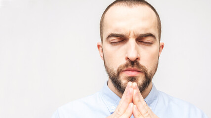 Bearded man praying hard, religious man, copy space, portrait, white background, close-up, 16:9
