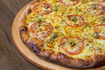 ricardo fernando franca junior pizza mussarela muçarela mucarelGastronomic photo of a Mozzarella Cheese Pizza with slices of red tomatoes on a wooden board. Typical Italian food.