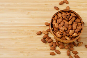 Organic almond nut raw peeled in bowl on wooden table, top view. Healthy snack or for vegetarians. 