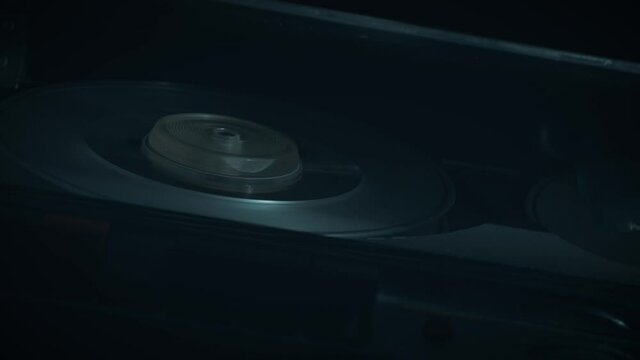 
Macro shots of a 1970s quarter-inch open-reel tape recorder in operation. Shallow depth of field with focus on the rotating spools. Suggestive of a wiretap or surveillance. 