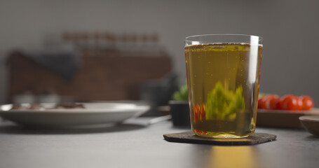 pour apple cider in a tumbler glass on concrete countertop with window on background