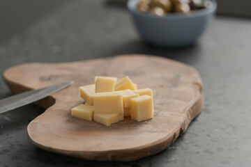 Pieces of hard vintage cheese on wood olive board