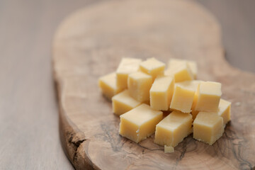 Pieces of hard vintage cheese on wood olive board