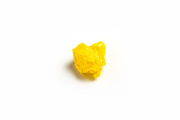 Ball of crumpled yellow scotch tape on a white background. Top view, flat lay.