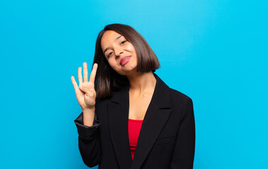 hispanic woman smiling and looking friendly, showing number four or fourth with hand forward,...