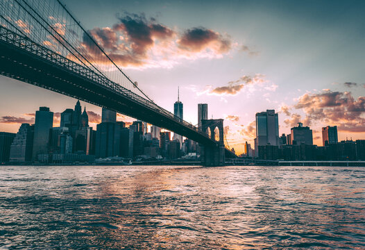 Cable-stayed Brooklyn Bridge and New York City skyline with modern high-rise buildings at twilight