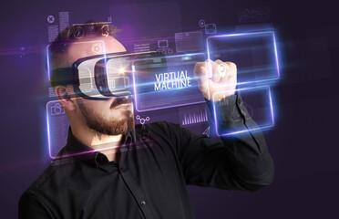 Businessman looking through Virtual Reality glasses with VIRTUAL MACHINE inscription, new technology concept
