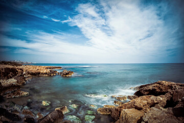 Fototapeta na wymiar Paisaje con larga exposición de la costa de rocas en santa Pola del Este