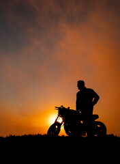 Obraz na płótnie Canvas Motorbiker in the sunset, Azores, Sao Miguel island, silhouette, vertical.
