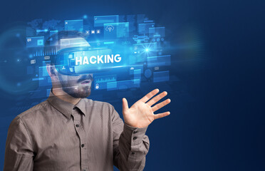 Businessman looking through Virtual Reality glasses with HACKING inscription, innovative security concept