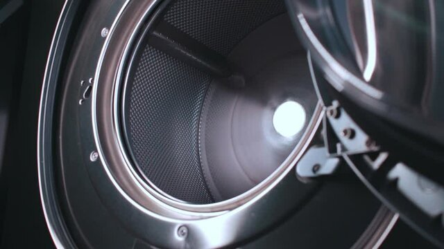 inside shot of professional industrial washing machine metallic drum at laundry