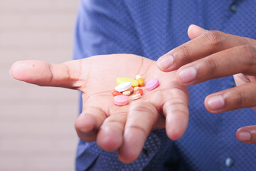 Close up of man hand holding pills and capsule with copy space 
