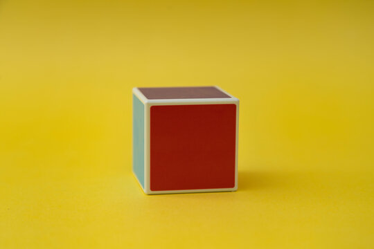 Blank wooden cube on yellow background.