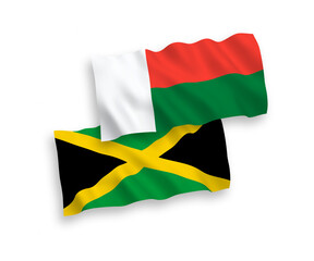 National vector fabric wave flags of Jamaica and Madagascar isolated on white background. 1 to 2 proportion.